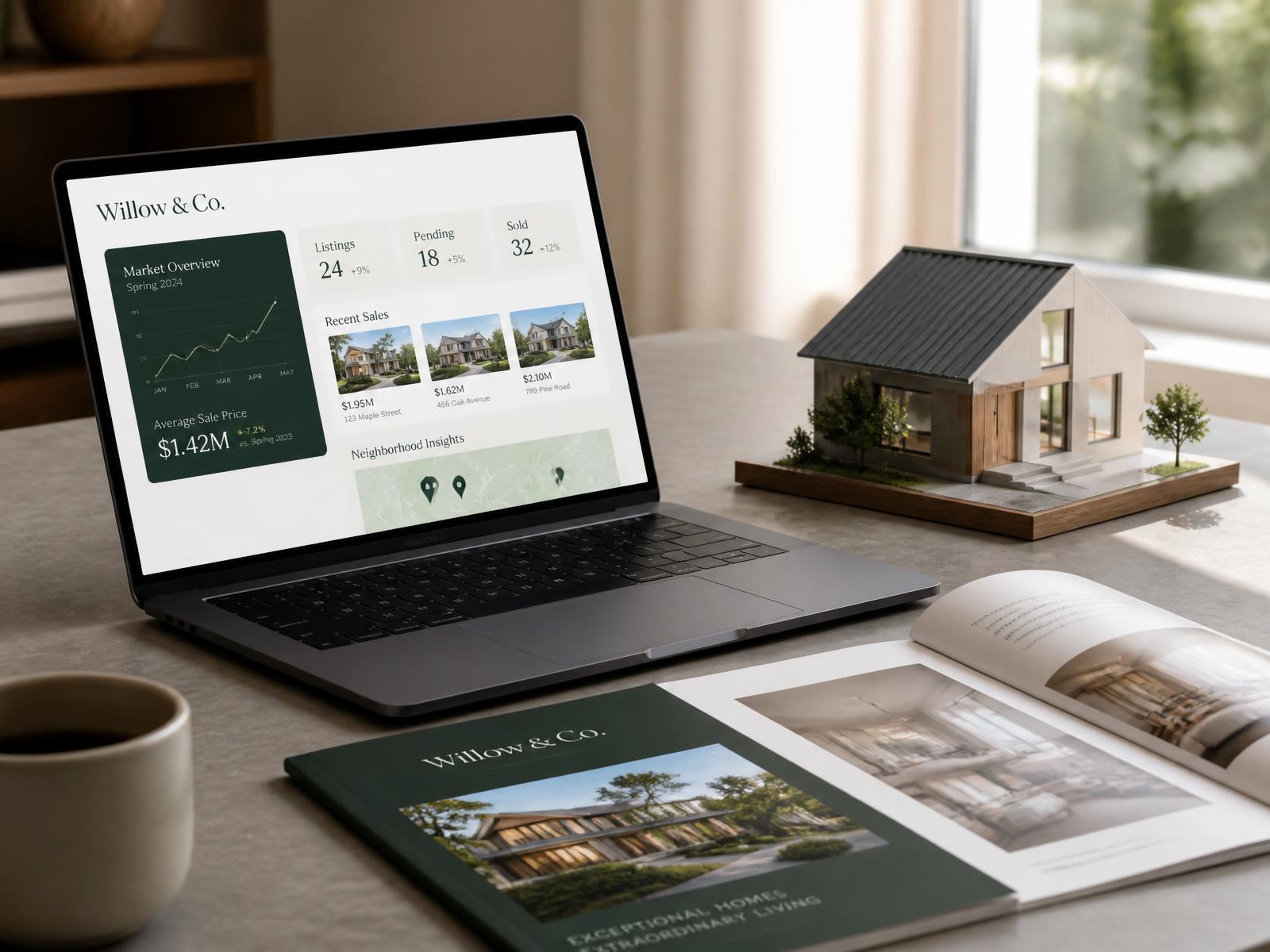 Laptop showing a real estate marketing dashboard next to a printed brochure and a house model